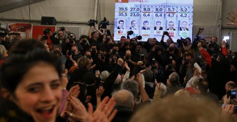 Los seguidores de Syriza observan en un panel los resultados de las elecciones adalantados por los sondeos a pie de urna. REUTERS/Marko Djurica