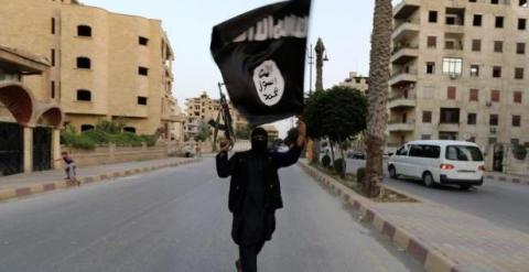 Militante del Estado Islámico agita la bandera negra de su organización. Foto: Reuters