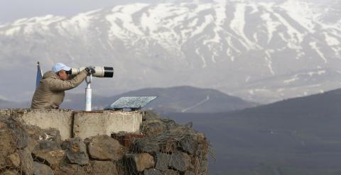 Un miembro de UNDOF observa con unos binoculares el monte Bental, en el Golan. REUTERS