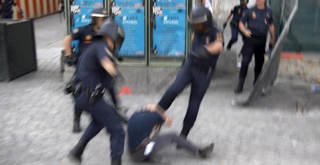 Tres agentes de la Policía Nacional golpean a un manifestante.- AMNISTÍA INTERNACIONAL