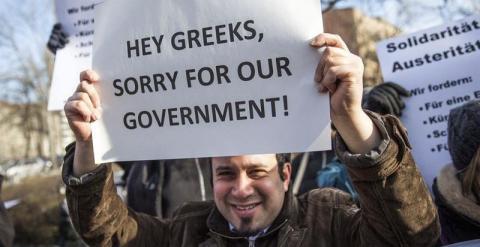 'Hey griegos, perdón por nuestro Gobierno'. Un manifestante sujeta un cartel durante una protesta frente al Ministerio de Finanzas alemán. - EFE