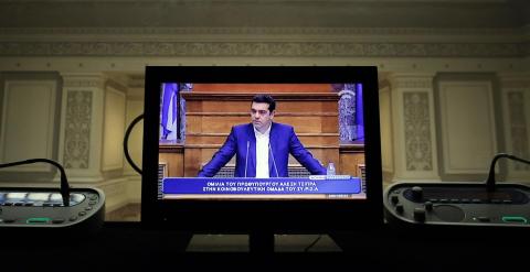 La imagen del primer ministro griego, Alexis Tsipras, en un monitor de una cabina de traduccióm simultánera, durante una reunión con los diputados de Syriza en el Parlamento heleno. REUTERS/Kostas Tsironis