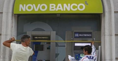 Unos trabajadores instalan el nuevo logo del portugués Novo Banco en una de sus sucursales de Lisboa. REUTERS