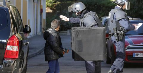 Un miembro del Grupo de Intervención de la Policía insta a un niño a abandonar la zona donde se ha producido el tiroteo. - REUTERS