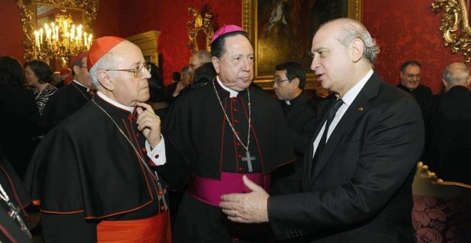 El ministro del Interior Jorge Fernández Díaz (d) charla con el cardenal Ricardo Blázquez (i) y con el arzobispo Castrense Juan del Río Martín (c), durante la recepción de ayer en la Santa Sede. EFE