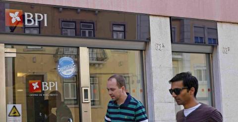 Dos personas pasan junto a una de las sucursales del banco BPI en Lisboa. REUTERS/Hugo Correia