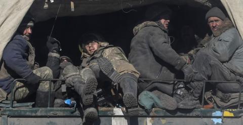 Tropas ucranianas se suben a un vehículo militar para abandonar Debáltsevo. - REUTERS