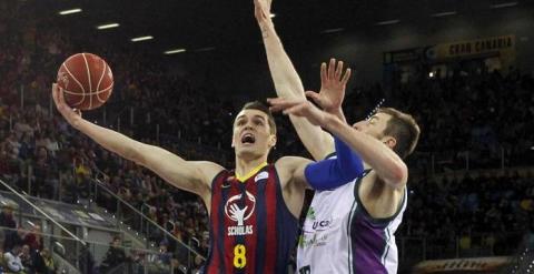 El azulgrana Mario Hezonja entra a canasta ante el pivot del Unicaja Fran Vázquez. / EFE