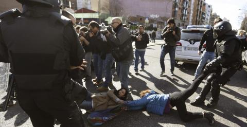 Agentes de Policía Municipal tratan de mover a varias de las personas que trataban de evitar el desalojo de la vivienda en el número 29 de la calle Ofelia Nieto./EFE-Javier Lizón