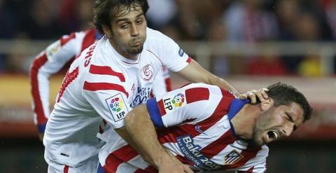 Arribas y Raúl García luchan por un balón durante el partido. EFE/Julio Muñoz