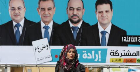 Una mujer pasea junto a un cartel de la lista árabe unida. - REUTERS