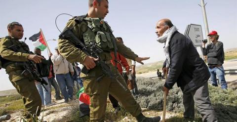 Soldados israelíes impiden que los palestinos planten olivos en tierra anexionada por la colonia judía de Ma'on, junto a Hebrón. ABED AL HASLHAMOUN / REUTERS