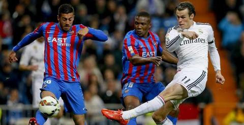 El centrocampista galés del Real Madrid Gareth Bale (d) dispara ante los jugadores del Levante Víctor Camarsa (i) y el mozambiqueño Simao, durante el partido de Liga en Primera División disputado esta noche en el estadio Santiago Bernabéu, en Madrid. EFE/