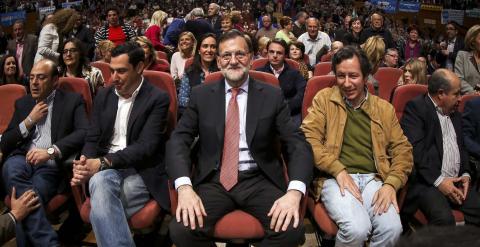 El presidente del Gobierno, Mariano Rajoy, sentado entre el candidato del PP en Andalucía Juan Manuel Moreno Bonilla y el vicesecretario general del partido Carlos Floriano en un mitin en Granada. REUTERS/Pepe Marin