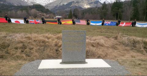 Placa conmemorativa descubierta durante la ceremonia con las banderas de todas las nacionalidades de los fallecidos de fondo. Foto: Embajada alemana en Francia