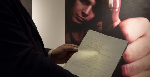 Un empleado de la casa de subastas Christie's sujeta el  manuscrito original del cantante Don McLean de 'American Pie', su tema más famoso. REUTERS/Brendan McDermid