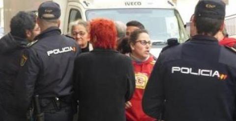 Juliana Garlito, al fondo a la izquierda, siendo detenida por la Policía tras entrar a una vivienda social vacía propiedad de la Junta de Extremadura.