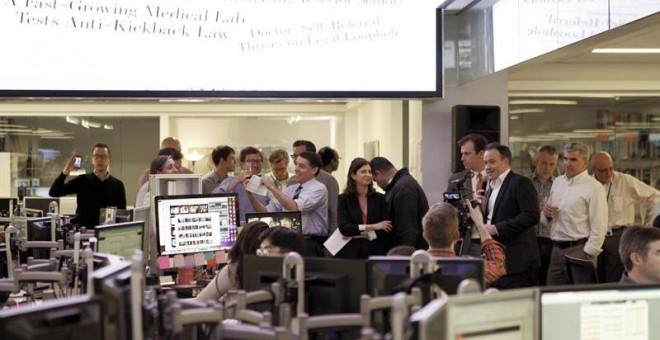 Editores y periodistas del Wall Street Journal brindan en la sala de redacción. EFE