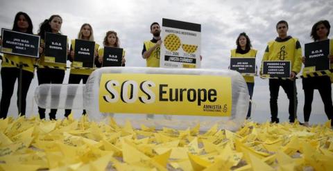 Acción de AI bajo el lema 'SOS Europe' en un playa de Barcelona. / EFE