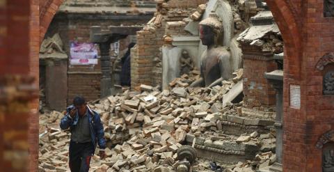 Un hombre llora mientras camina por la calle mientras junto a una estatua de Buda dañada un día después de un terremoto en Bhaktapur, Nepal.- REUTERS / Navesh Chitrakar
