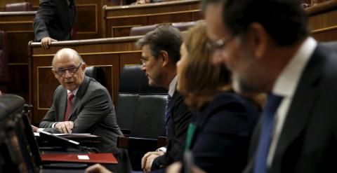 El ministro de Hacienda, Cristóbal Montoro, conversa, antes del comienzo de la sesión de control en el Pleno del Congreso, con el presidente del Gobierno, Mariano Rajoy, la vicepresidenta Soraya Saenz de Santamaria, y el titular de Justicia, Rafael Catala