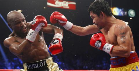 Mayweather se defiende de un golpe de Pacquiao. /REUTERS