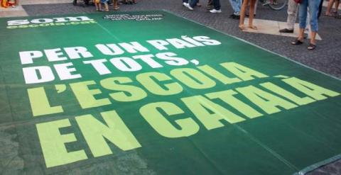 Pancarta con el lema 'Por un país de todos, la escuela en catalá' en una manifestación por la inmersión lingüística./ ACN