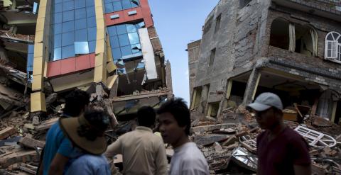 Varias personas observan edificios derrumbados por el nuevo terremoto en Katmandú. /REUTERS