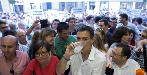 El secretario general del PSOE, Pedro Sánchez, en una heladería, con la protesta al fondo.  EFE/Jorge Zapata.