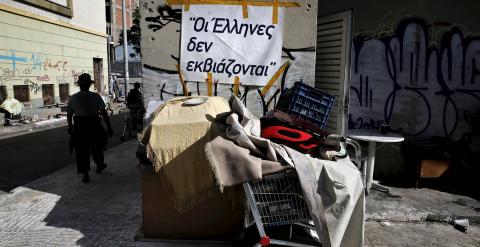 Las pertenencias de un sintecho, en el puerto ateniense del Piero, con un cartel que dice 'Griegos no pueden ser chantajeados'. REUTERS/Alkis Konstantinidis