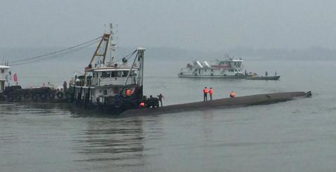 Una grúa intenta voltear al barco hundido en el río Yangtsé. /REUTERS