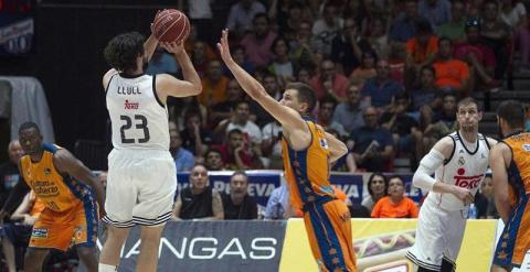 El alero del Real Madrid, Sergio Llul (i), lanza un triple a falta de 1,8 segundos de la prórroga, consiguiendo la victoria ante el Valencia Basket. /EFE