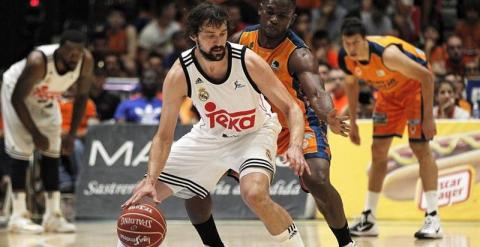 El escolta del Real Madrid, Sergio Llull, ante la defensa del alero centroafricano del Valencia Basket, Romain Sato. /EFE