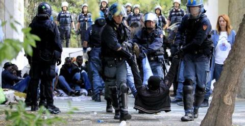 Agentes arrastran a uno de los inmigrantes atrapados en Ventimiglia. - AFP