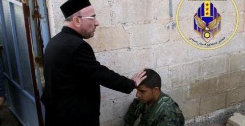 Sacerdote bendice a un miliciano del Consejo Militar Siriaco de Siria.