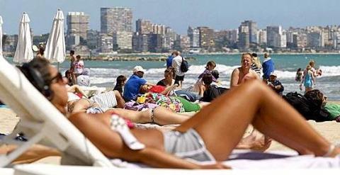 Turistas toman el sol en una playa de Alicante. EFE