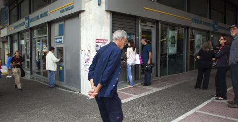 Varias personas esperan para sacar dinero en un cajero automático en Atenas. EFE/Alexandros Vlachos