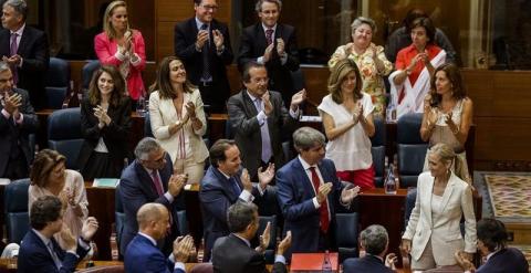 La candidata del PP a la Presidencia de la Comunidad de Madrid, Cristina Cifuentes (d), es aplaudida por los diputados de la Asamblea de Madrid tras ser elegida nueva presidenta de la Comunidad durante la segunda jornada del debate de investidura que se c