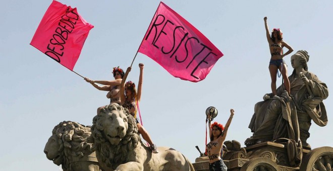 Cuatro activistas de Femen se han encaramado hoy en una acción sorpresa a la fuente de Cibeles para protestar contra la ley mordaza.- EFE/Juan Carlos Hidalgo