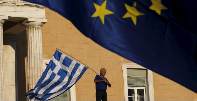 Un hombre ondea una bandera griega frente al Parlamento del país heleno. - REUTERS