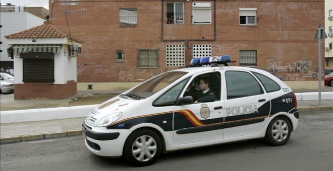 Un coche de la Policía Nacional pasa por un barrio de Sevilla. EFE/Archivo