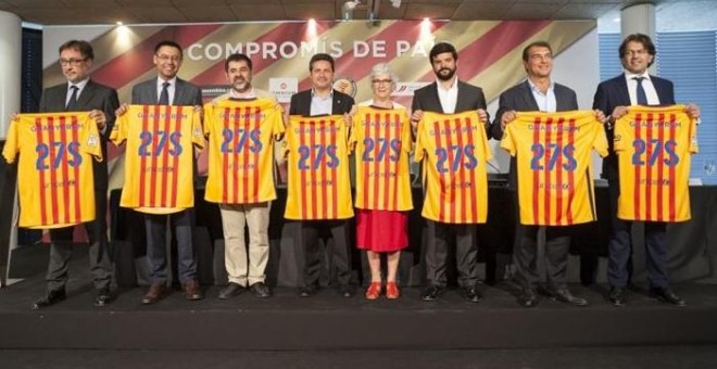 Los cuatro candidatos, junto a representantes de las organizaciones propulsoras del documentos, posan con la camiseta cuatribarrada del Barça y el lema 'Guanyarem 27S'.