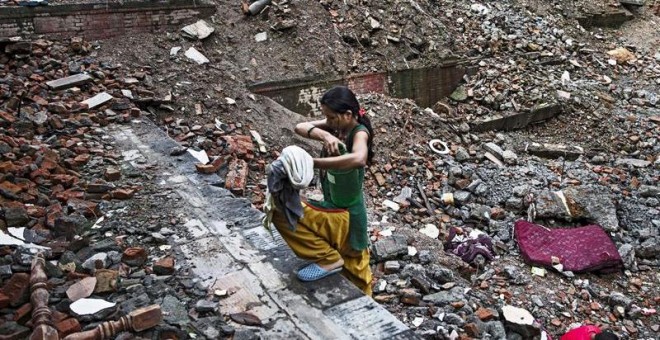 Una mujer nepalí carga con un bidón de agua en Thamel, Katmandú (Nepal).- EFE.