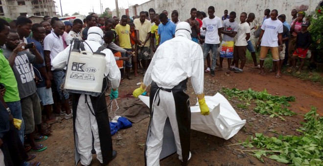 Trabajadores sanitarios mueven el cadáver de una posible víctima de ébola en Monrovia, Liberia. - REUTERS