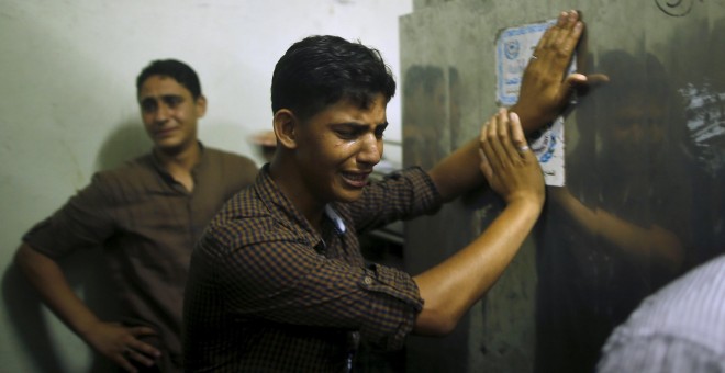 Un amigo del joven asesinado por Israel llora en la morgue hasta donde ha sido trasladado el cuerpo del fallecido. REUTERS