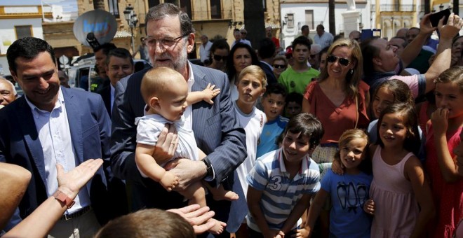 El presidente del Gobierno, Mariano Rajoy, saluda a varios vecinos de La Palma del Condado (Huelva). REUTERS