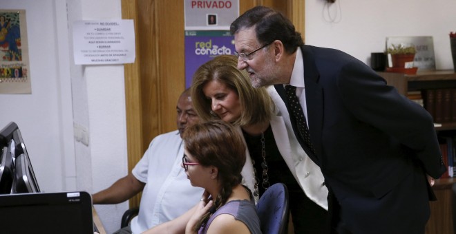 El presidente del Gobierno, Mariano Rajoy, con la ministra de Emlpeo y Seguridad Social, Fátima Bañez, durante su visita a la Fundación Tomillo. REUTERS/Juan Medina