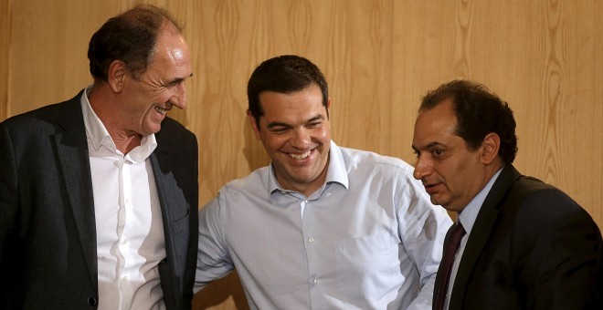 El primer ministro griego, Alexis Tsipras, con el ministro de Economía,  Giorgos Stathakis, y el de Infraestructuras, Christos Spirtzis, tras un acto  en Atenas, el primero tras el acuerdo entre el Ejecutivo heleno y la troika para el tercer rescate del p