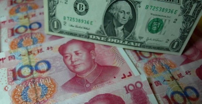 Billetes de yuan junto al de un dólar en un banco chino. - AFP