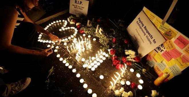 Tailandeses encienden velas en memoria de las víctimas en la explosión de una bomba ayer en Bangkok (Tailandia). EFE/Ritchie B. Tongo